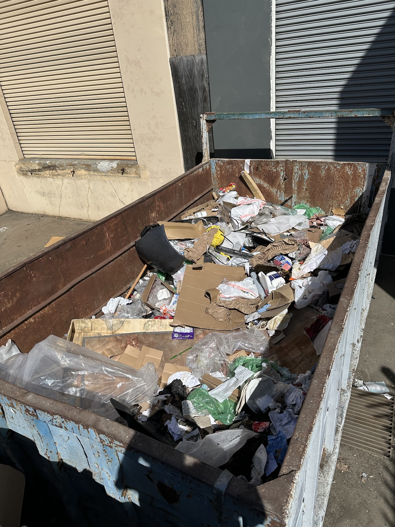 Commercial dumpster filled before JR Brothers hauled the contents